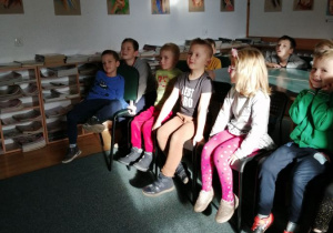dzieci słuchają bajki czytanej przez bibliotekarkę